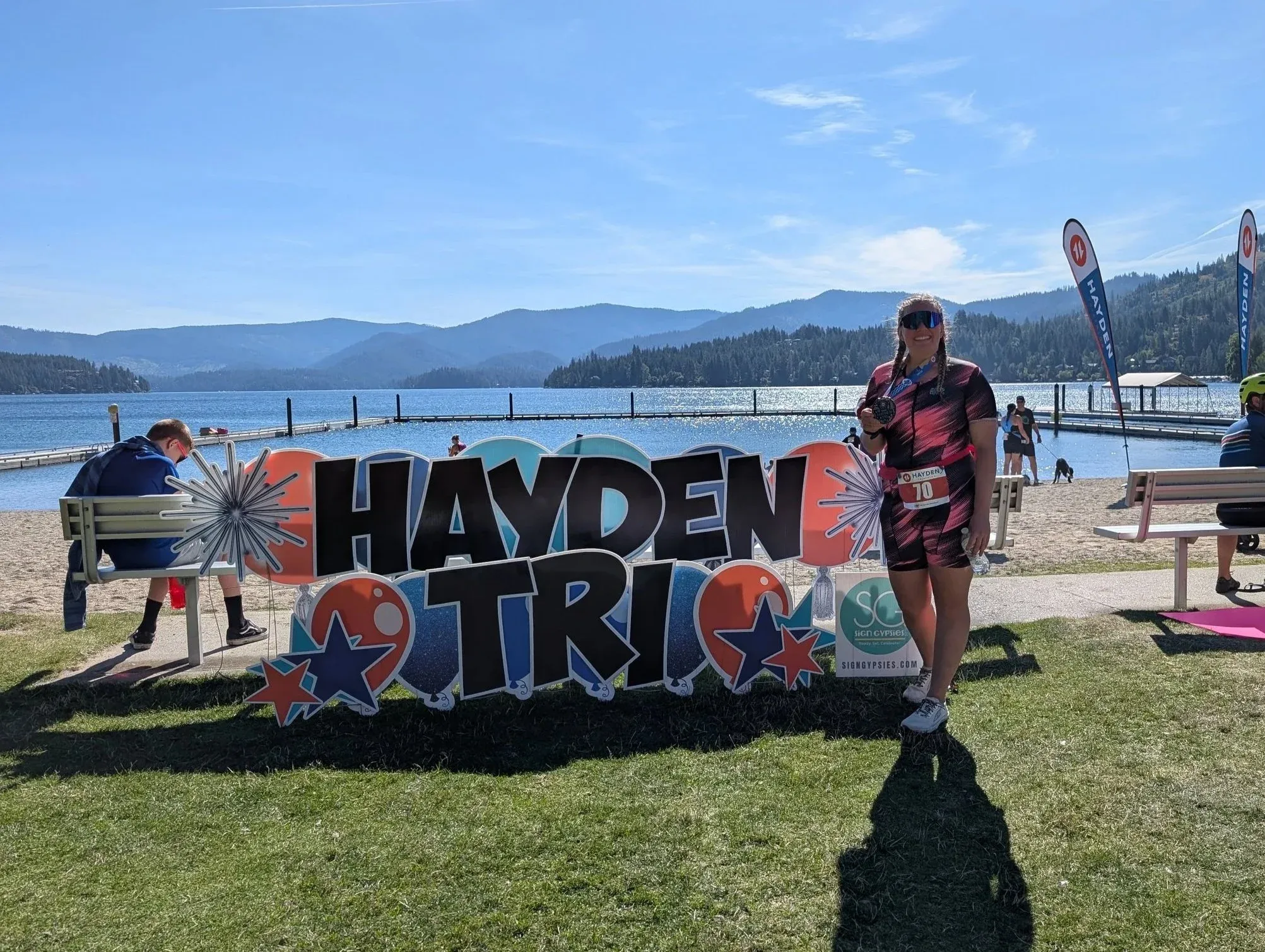 The Hayden Tri sign on the grass by the lake on race morning.