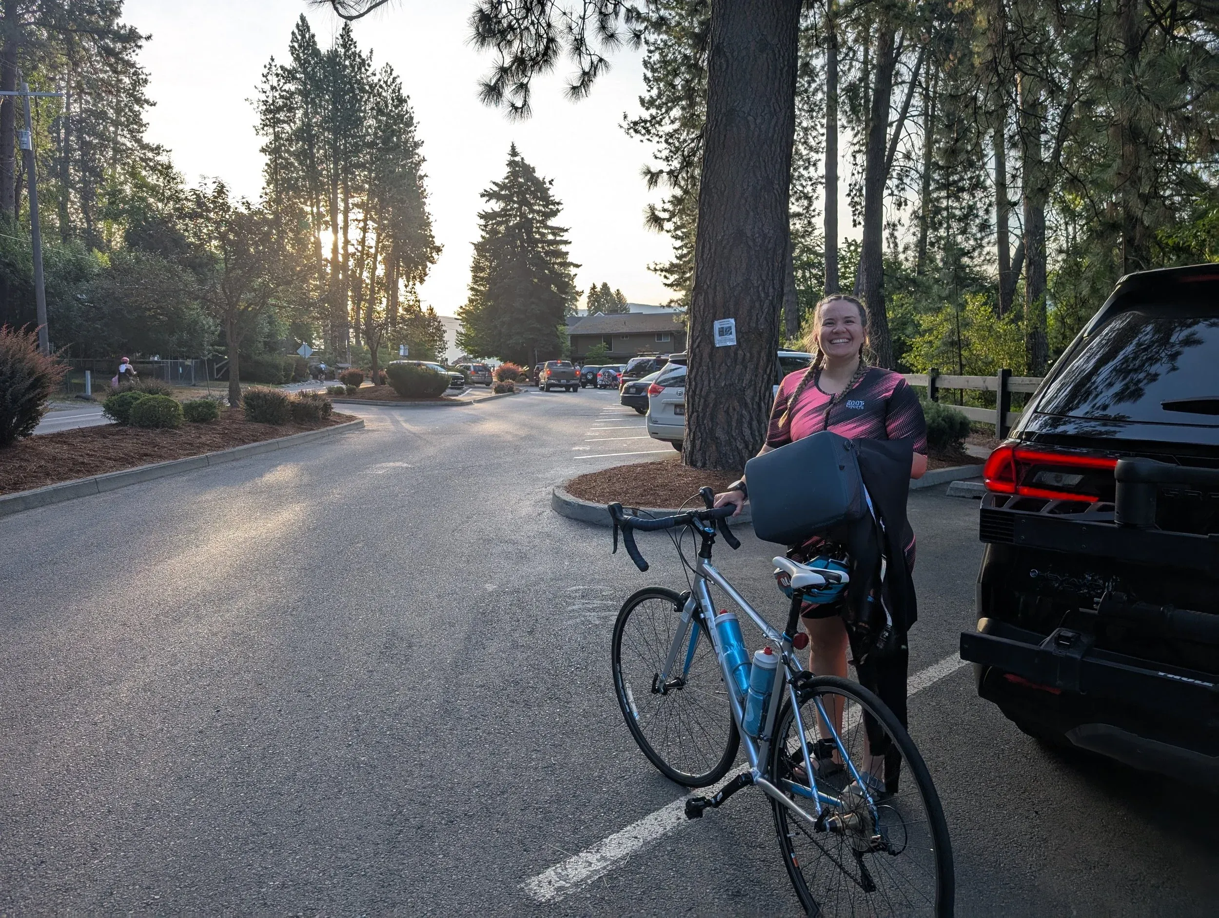 Jen with her road bike at the roadside before a training ride.
