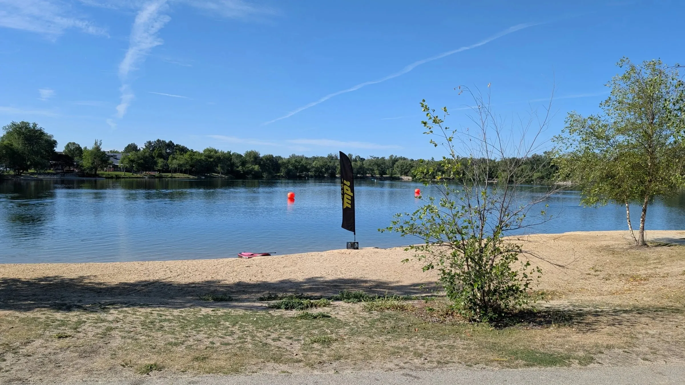 A marker buoy on flat open water under a clear sky.
