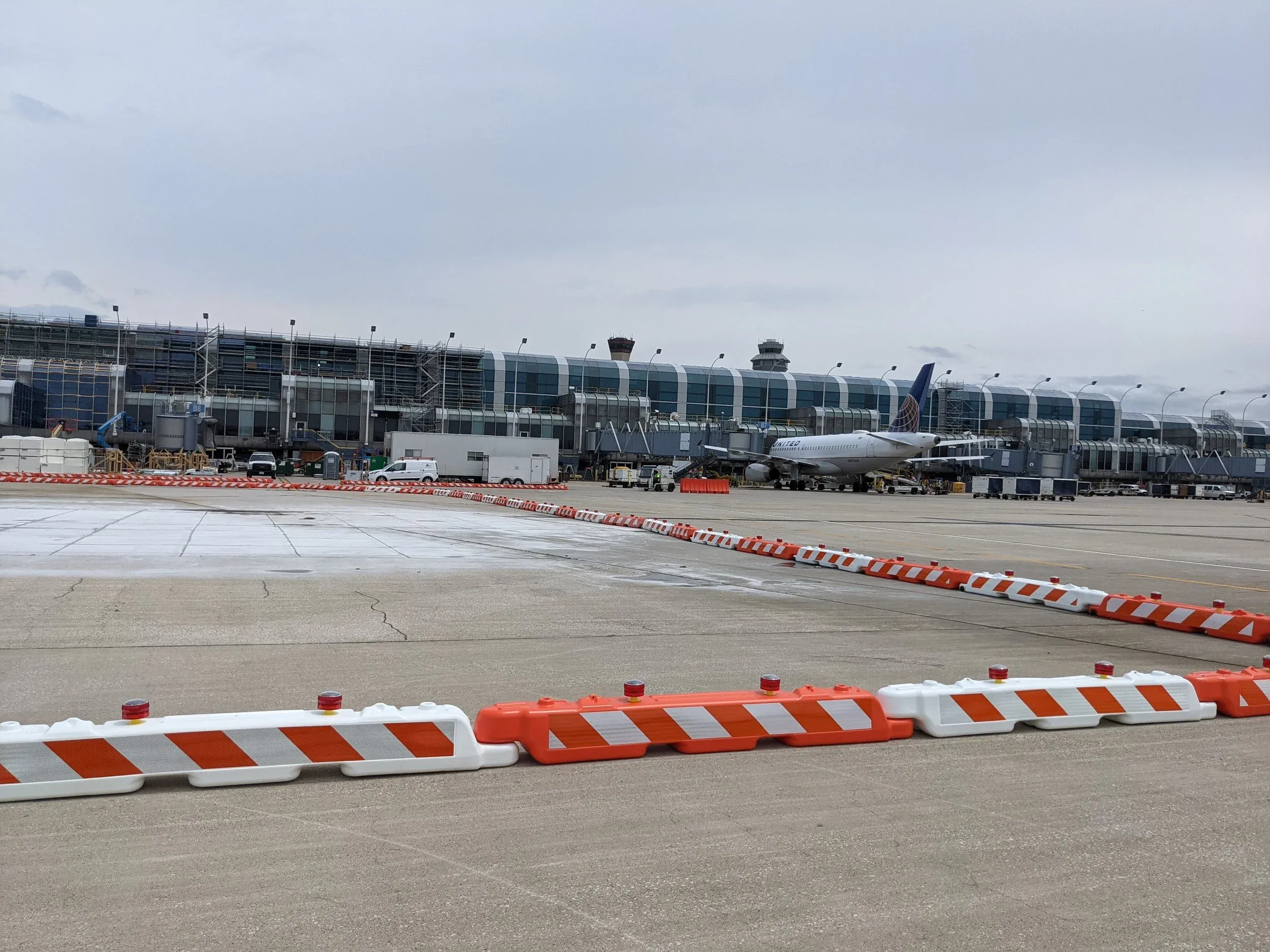 Orange and white barricades closing off pavement repairs on the airfield at O’Hare.