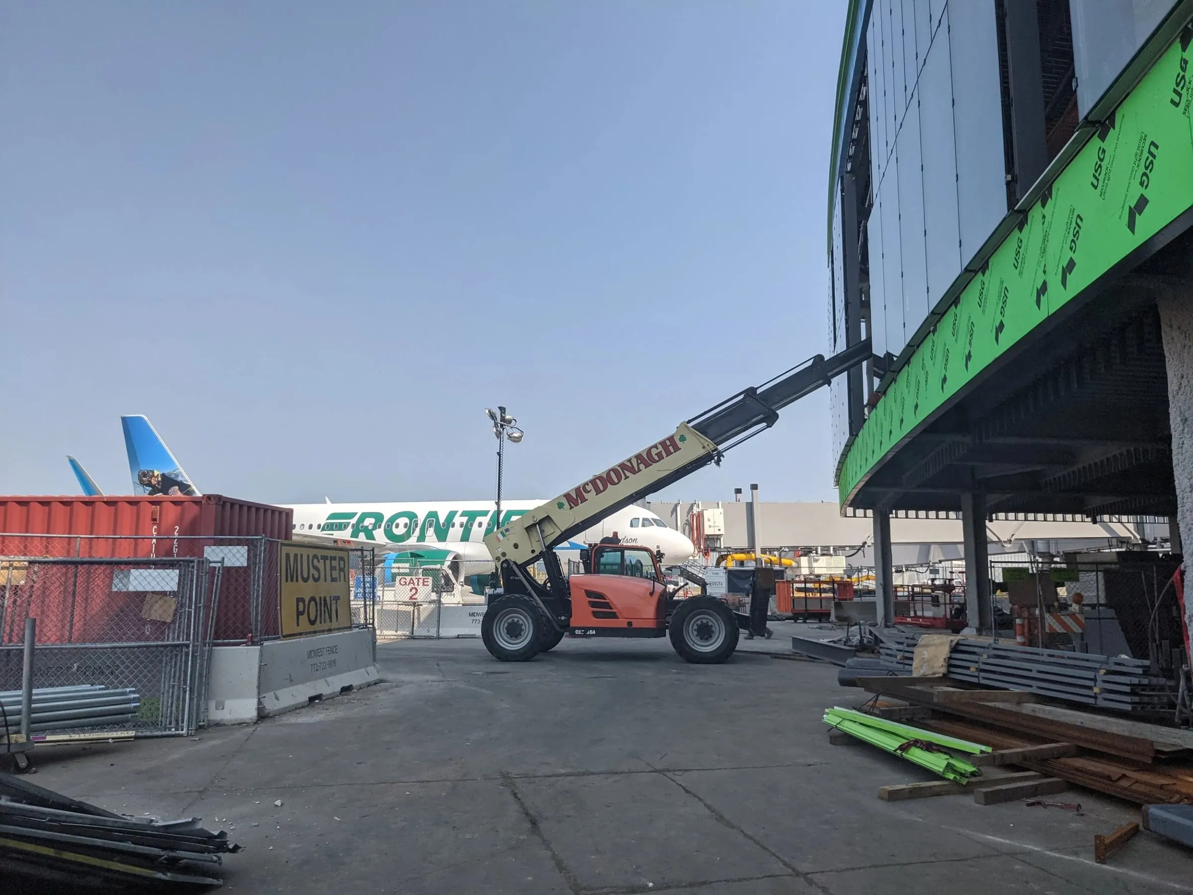 Curtainwall panels being lifted into place by a telehandler at O'Hare Terminal 5.