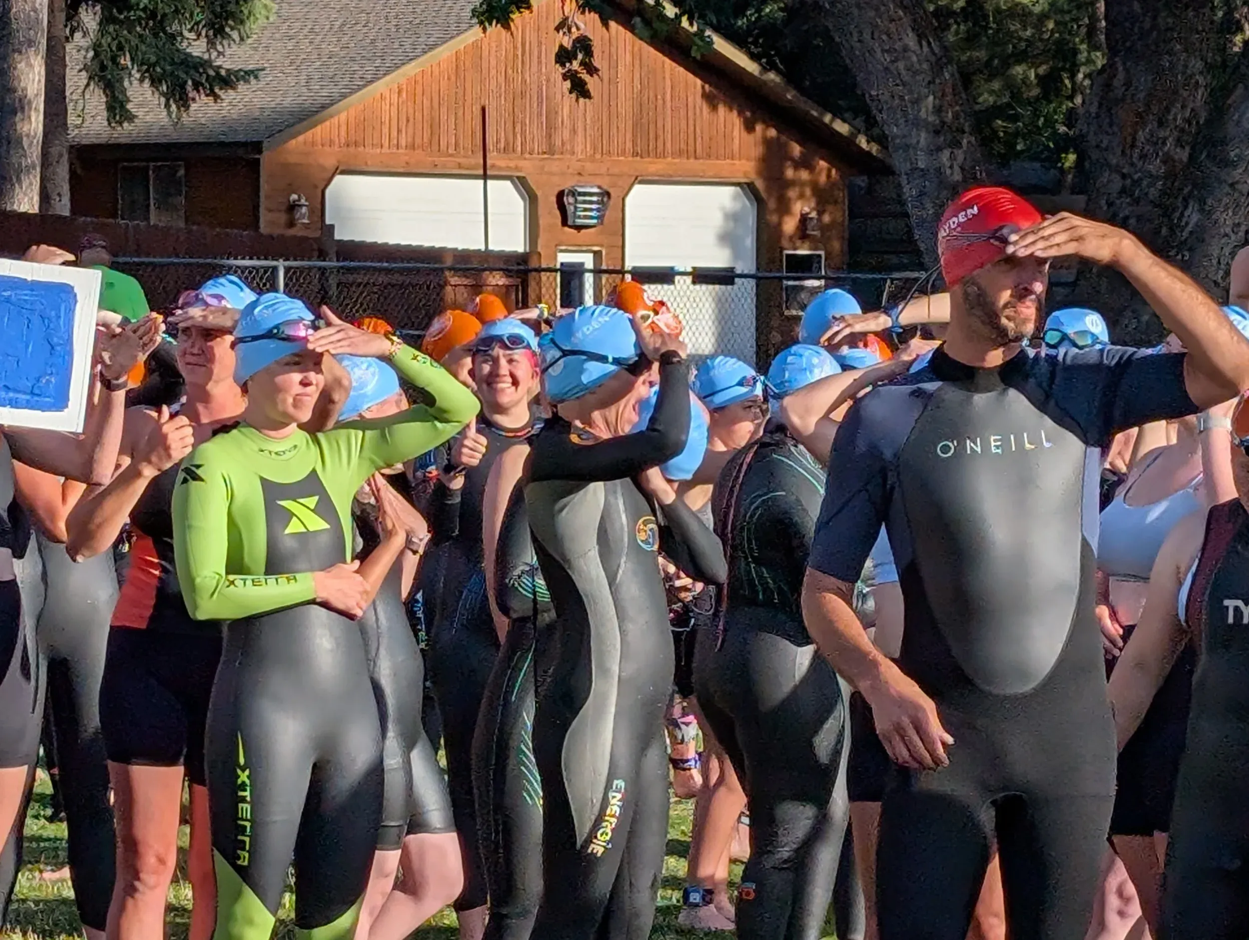 Competitors in wetsuits and swim caps gathered before the swim start.